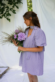 Robe fluide courte col V portée par une femme, vue de trois-quarts, bouquet violet