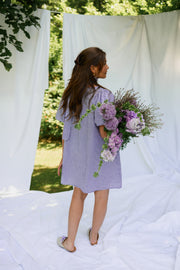 Robe fluide courte col V portée par une femme, vue de dos, drapés, bouquet
