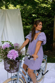 Robe fluide courte col V portée par une femme, silhouette entière, vélo, fleurs
