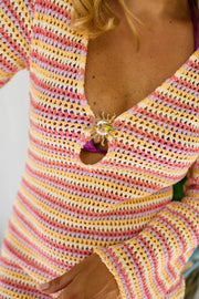Robe courte en crochet portée par une femme, vue rapprochée, col V, maille crochet rose et jaune