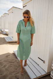 Robe en maille ajourée portée par une femme, vue de face, cabines, pieds nus