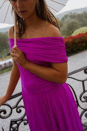 Robe longue effet tulle portée par une femme, vue rapprochée, épaule drapée, parasol