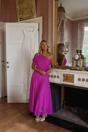 Robe longue effet tulle portée par une femme, vue de face, cheminée, salon