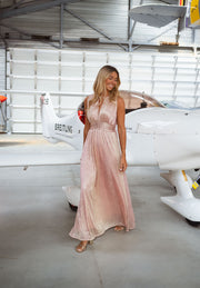 Robe fluide à taille resserrée portée par une femme, vue de face, hangar, avion