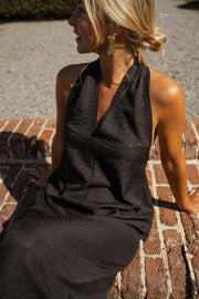 Robe fluide à dos ouvert portée par une femme, vue rapprochée, col halter, cheveux blonds