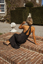 Robe fluide à dos ouvert portée par une femme, assise, dos ouvert