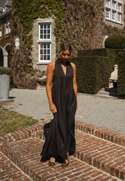 Robe fluide à dos ouvert portée par une femme, silhouette entière, lierre, fenêtre