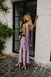 Robe asymétrique en soie fendue portée par une femme, silhouette entière, fente latérale, fenêtre noire