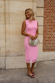 Robe moulante effet tulle portée par une femme, vue rapprochée, pochette argentée, robe rose