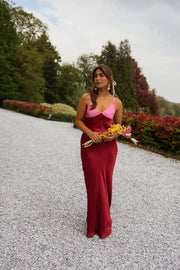 Robe longue en soie décolletée portée par une femme, silhouette entière, gravier, bouquet jaune