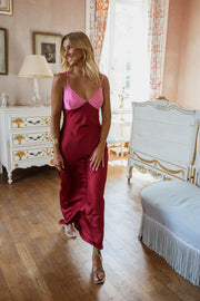 Robe longue en soie décolletée portée par une femme, silhouette entière, commode blanche, salon