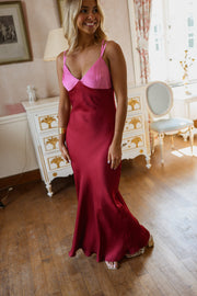 Robe longue en soie décolletée portée par une femme, vue rapprochée, bretelles roses, satin