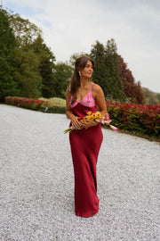 Robe longue en soie décolletée portée par une femme, en marchant, gravier, bouquet