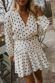 Robe cache-cœur à pois portée par une femme, vue de trois-quarts, manches longues, terrasse