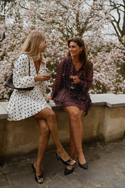 Robe cache-cœur à pois portée par une femme, silhouette entière, deux femmes, magnolias