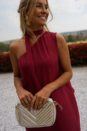 Robe longue en soie asymétrique portée par une femme, vue rapprochée, col asymétrique, pochette argentée