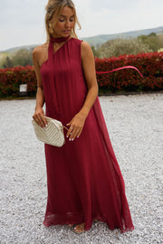 Robe longue en soie asymétrique portée par une femme, silhouette entière, allée de gravier, pochette