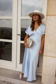 Robe satinée à manches courtes portée par une femme, vue de trois-quarts, porte-fenêtre, chapeau
