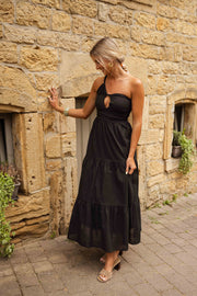 Robe longue effet lin portée par une femme, en marchant, mur en pierre, volants
