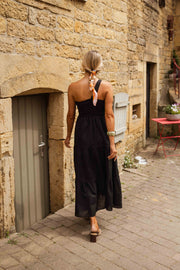 Robe longue effet lin portée par une femme, vue de dos, porte, volants