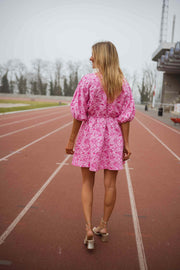Robe à manches ballon trois-quarts portée par une femme, vue de dos, piste, cheveux blonds