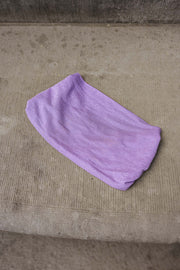 Robe longue pailletée fendue portée par une femme, Robe longue à paillettes lilas posée à plat sur le sol