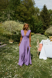 Robe longue pailletée fendue portée par une femme, silhouette entière, jardin fleuri, fente