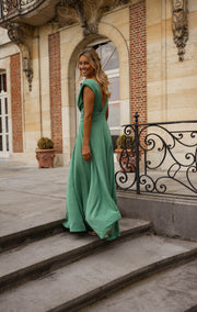 Robe longue à paillettes portée par une femme, silhouette entière, escalier, balustrade en fer forgé