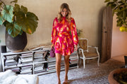Robe à manches longues volantée portée par une femme, silhouette entière, salon, plante verte