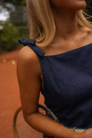 Robe courte en jean portée par une femme, vue rapprochée, bretelle, épaule