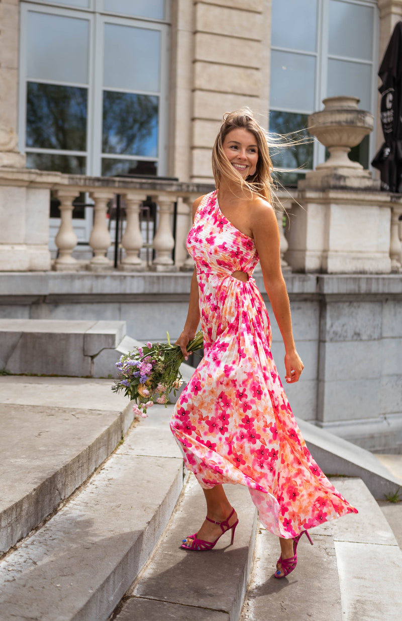 Robe fleurie à col asymétrique portée par une femme, vue de face, escalier, bouquet
