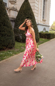 Robe fleurie à col asymétrique portée par une femme, en marchant, haies, bouquet