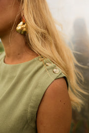 Robe courte taille resserrée portée par une femme, vue rapprochée, épaule, bouton