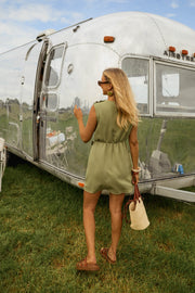 Robe courte taille resserrée portée par une femme, vue de dos, camping-car, sac
