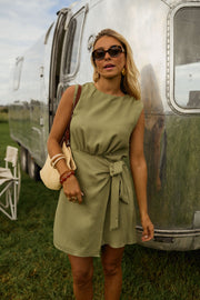 Robe courte taille resserrée portée par une femme, silhouette entière, camping-car, sac de paille