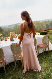 Robe longue fluide effet soie portée par une femme, vue de dos, bretelles croisées, tables