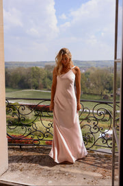 Robe longue fluide effet soie portée par une femme, silhouette entière, balcon, ciel