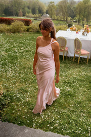Robe longue fluide effet soie portée par une femme, silhouette entière, pelouse, tables dressées