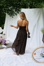 Robe longue effet plissé portée par une femme, vue de dos, drapés blancs, fleurs