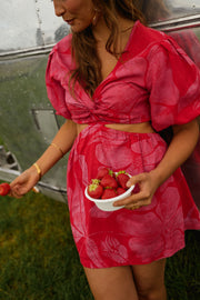 Robe courte à manches bouffantes portée par une femme, vue rapprochée, bol de fraises, manches bouffantes