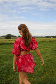 Robe courte à manches bouffantes portée par une femme, vue de dos, champ, herbe