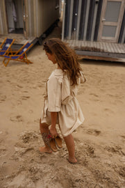 Robe cache-cœur à manches courtes portée par une femme, vue de dos, sable, dos