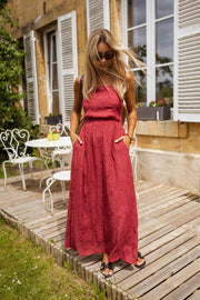 Robe brodée à col carré portée par une femme, silhouette entière, terrasse en bois, table