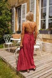 Robe brodée à col carré portée par une femme, vue de dos, terrasse, lacets