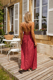 Robe brodée à col carré portée par une femme, vue de dos, lacets croisés, terrasse