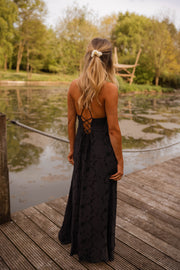 Robe brodée à poches portée par une femme, vue de dos, étang, cheveux attachés
