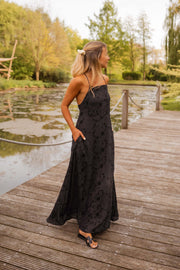 Robe brodée à poches portée par une femme, vue de face, ponton en bois, étang