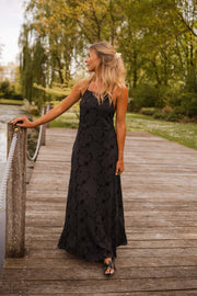 Robe brodée à poches portée par une femme, vue de face, ponton, main sur la corde