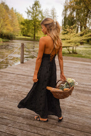 Robe brodée à poches portée par une femme, vue de dos, ponton, panier de fleurs