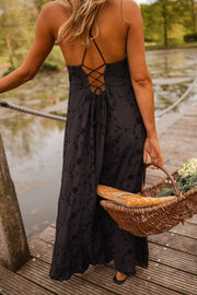 Robe brodée à poches portée par une femme, vue de dos, lacets croisés, panier